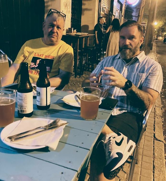 Steve and Brian enjoying a beer and food outside at a local restaurant.